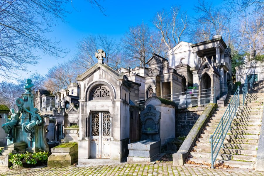 Best literary spots in Paris: This is an image of a section in Pere Lachaise cemetary with bold headstones.