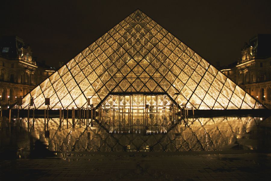 This is an image of the Louvre at night time all lit-up.