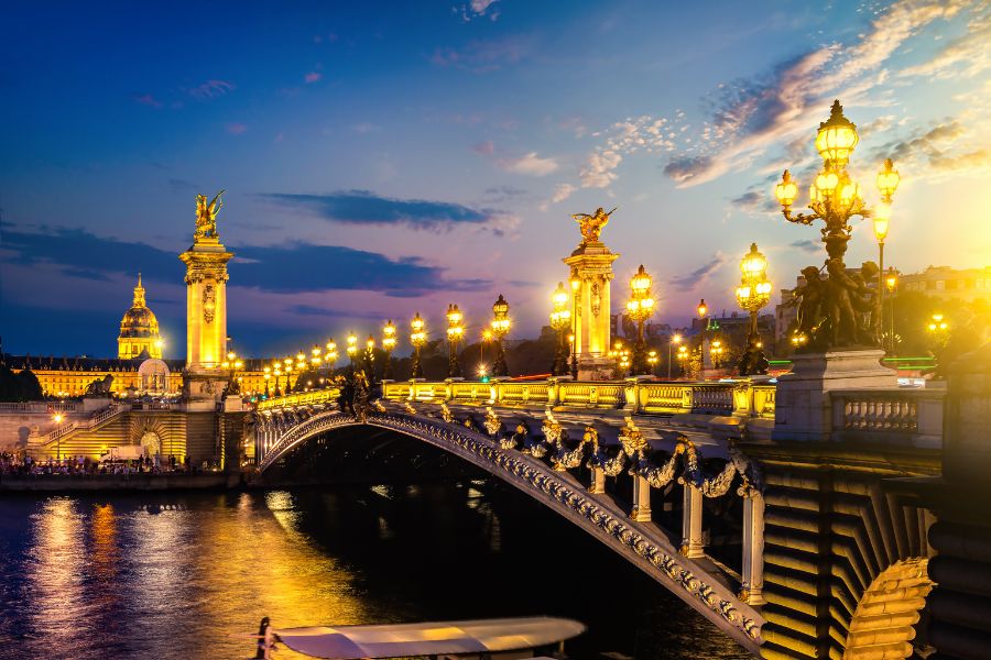 Emily in Paris filming locations: This is an image of the Pont Alexandre Bridge lit up in the evening.