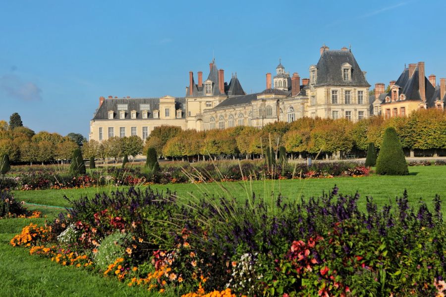 Château de Fontainebleau seen across colourful flowerbeds and manicured gardens