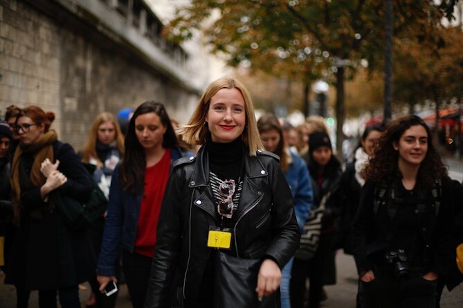 This is an image of a group of women walking in a group on the street. The woman in the centre is smiling.
