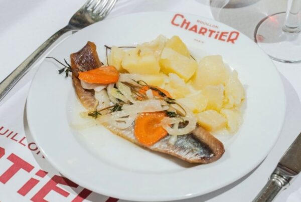 This is an image of a cold cured herring with pickled carrots and onions, alongside potatoes.