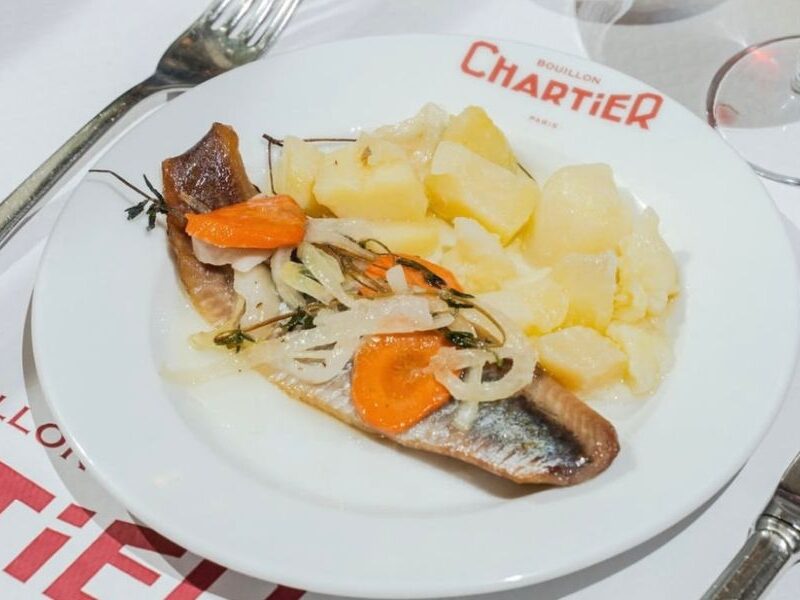 This is an image of a cold cured herring with pickled carrots and onions, alongside potatoes.