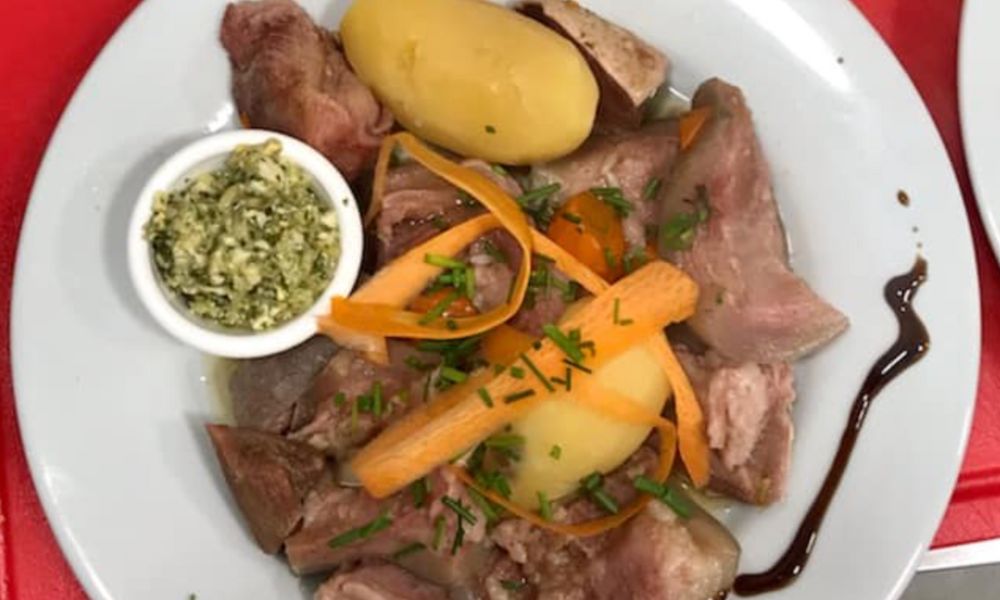 This is an image of steamed calf head with potatoes and carrots, plus a nice sauce.