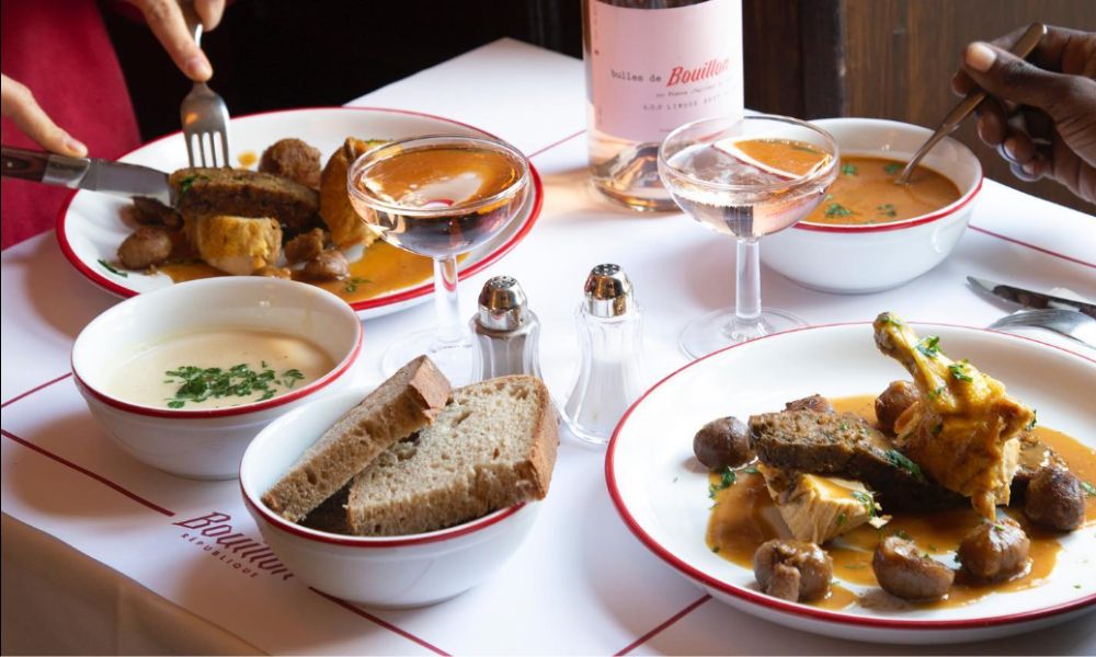 This is an image of a table at Bouillon Pigalle full of French food and wine.