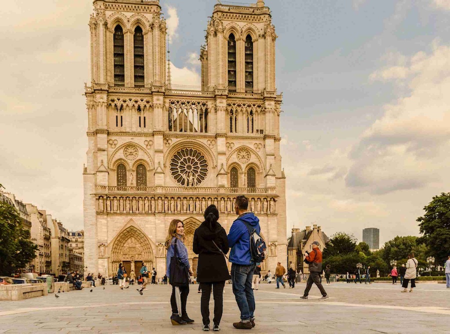Three people standing in front of Notre Dame