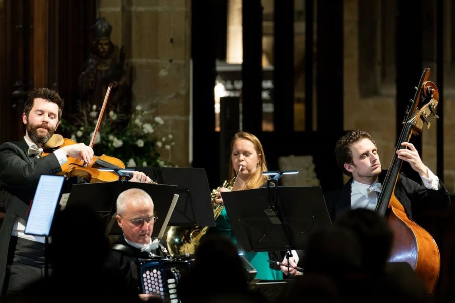 This is a picture of an orchestra playing their instruments on stage.