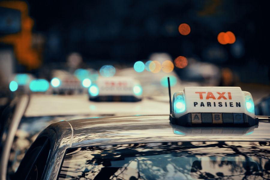 This is an image of a Parisien taxi line up at an airport with all their lights set to green.