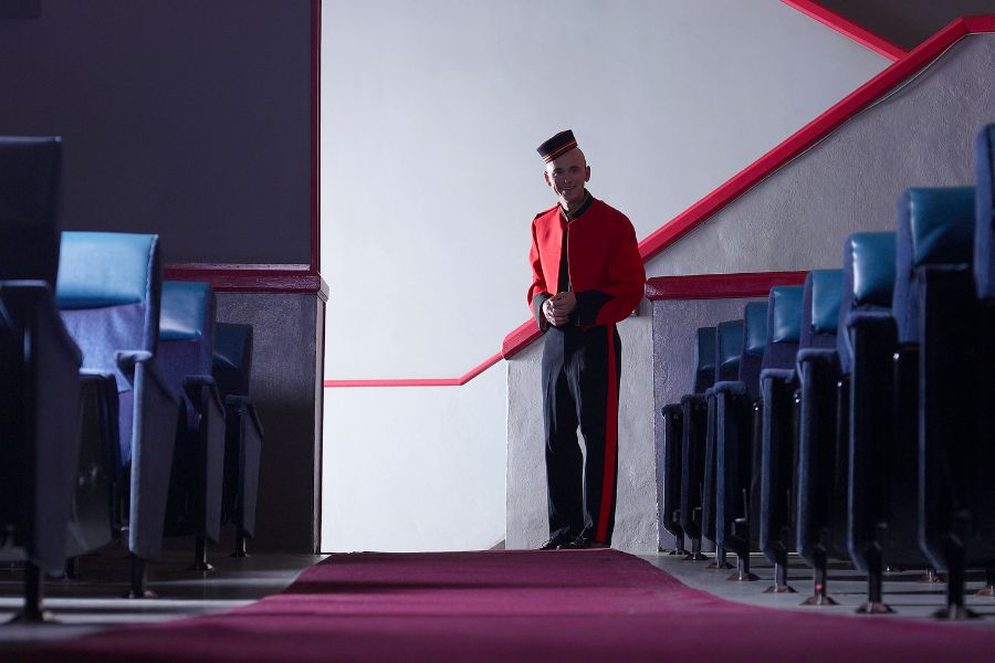 This is an image of an usher in a theatre waiting to greet customers.