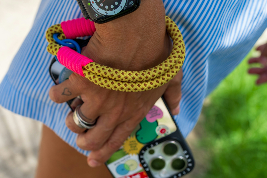 Phone secured with a wrist strap, one of the handy anti-theft travel devices for protecting your phone in crowded areas.
