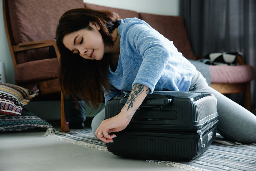 Traveller securing a suitcase with a lock, one of the practical anti-theft travel devices for keeping luggage safer in Paris.