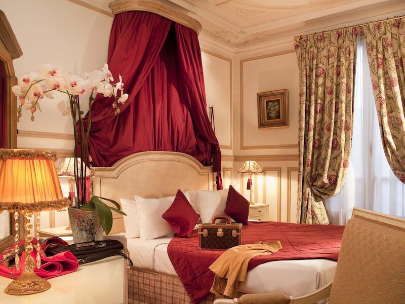 This is an image of a grand and luxurious hotel bedroom with decadent furniture.