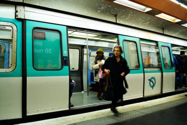 This is a picture of a woman stepping out of a Paris metro train.