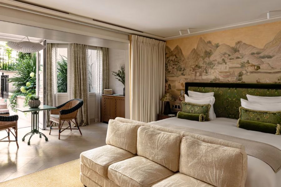 This is an image of a fancy hotel room in Paris with double folding doors that lead you outside.