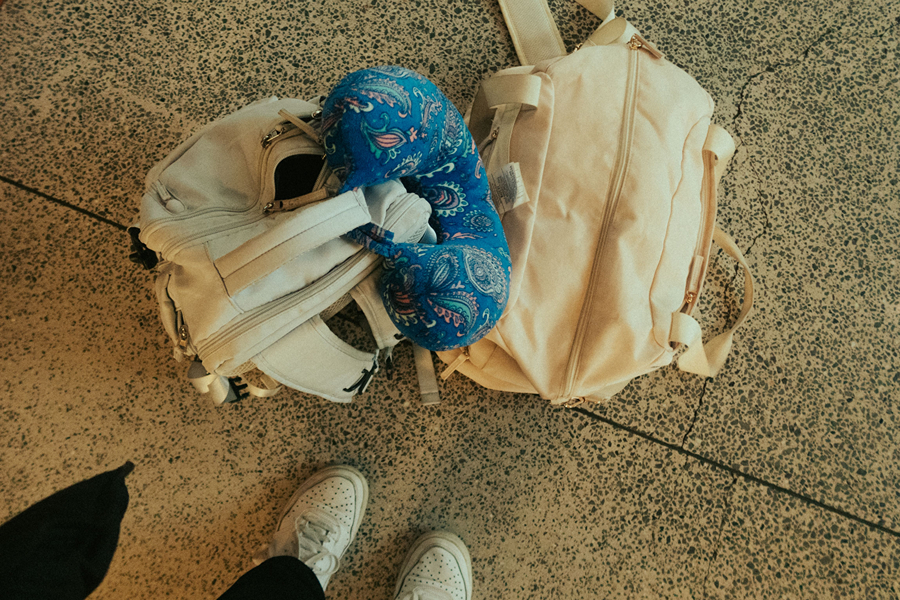 Travel pillow packed alongside luggage, one of the Paris travel accessories that can make a long journey more comfortable.