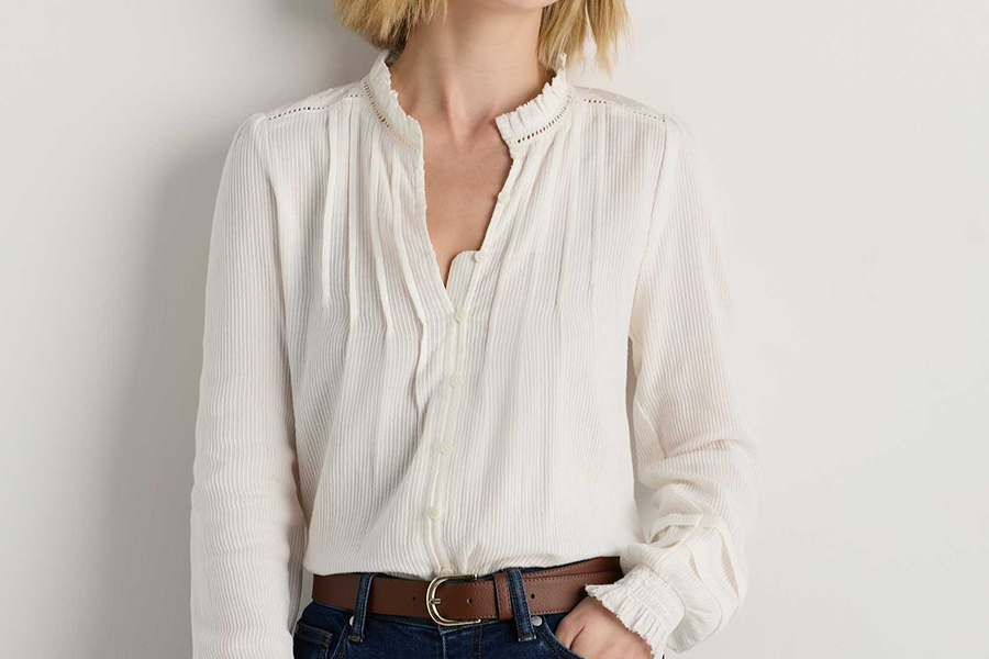 White ruffled blouse tucked into jeans, a polished everyday look inspired by Parisian style.