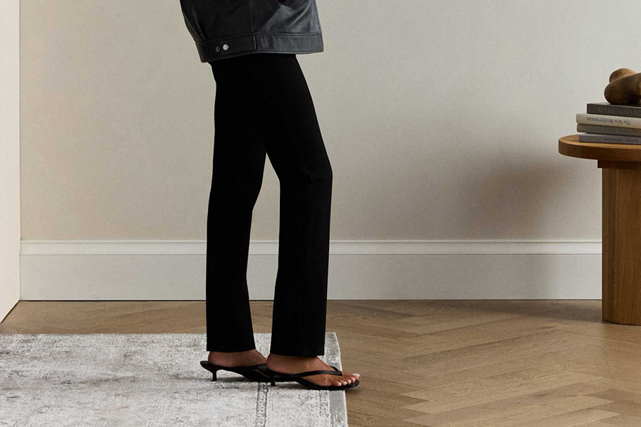 Black straight-leg trousers styled with a leather jacket and low heels for an easy Parisian-inspired outfit.
