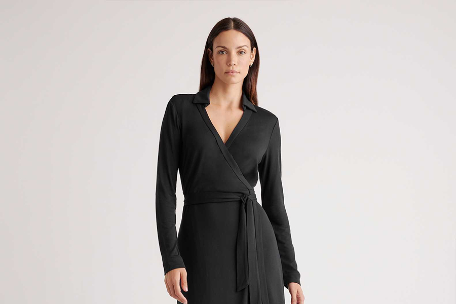 Woman wearing a black wrap dress, an elegant Paris-inspired look for daytime or dinner.