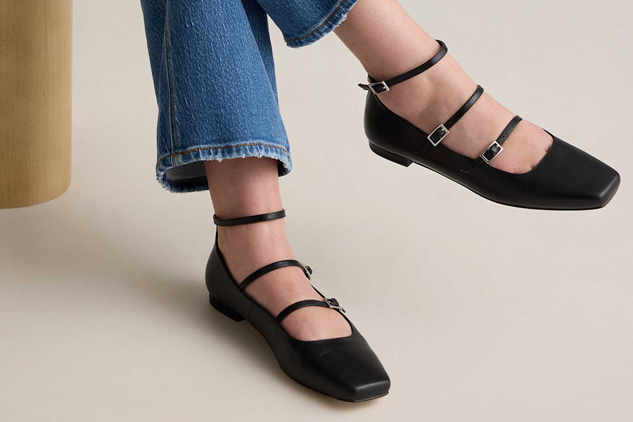 Black strappy ballet flats worn with jeans, a classic footwear choice for Parisian style.