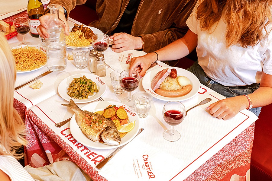 Diners enjoying classic French dishes at Bouillon Chartier, one of the family-friendly places to eat with kids in Paris.