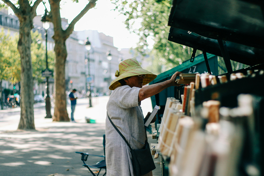 Shopper browsing a Paris market stall, a lovely way to spend part of Thanksgiving in Paris.