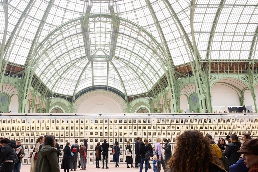 Visitors looking at framed photographs on display at a Paris photo fair