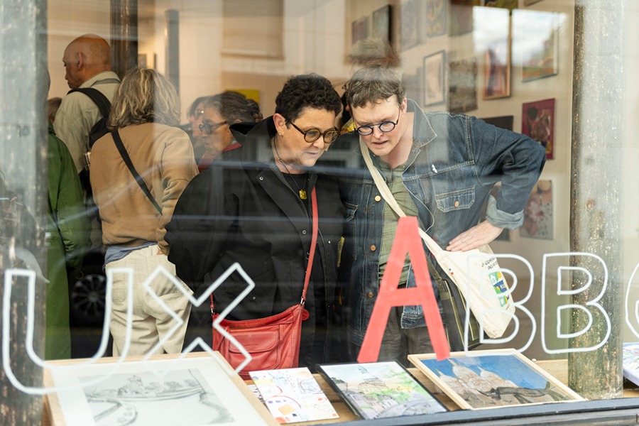 Visitors looking at framed photographs on display at a Paris art fair