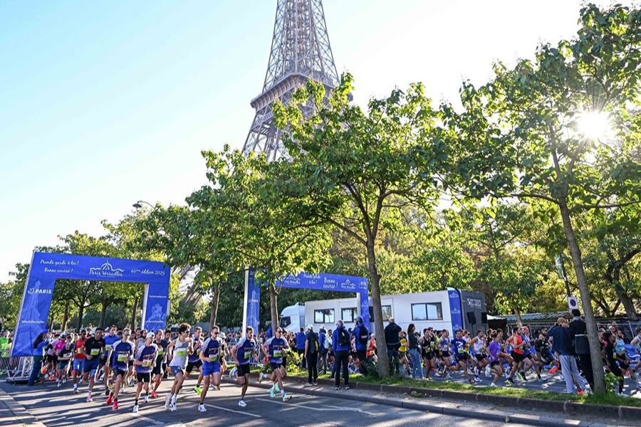 Runners at the start of the Paris-Versailles race near the Eiffel Tower, one of the best things to do in September in Paris.