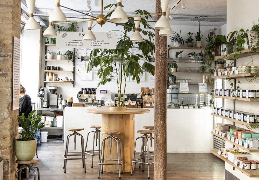 This is an image of the interior of a café with lots of seating, and shelves with health food products.