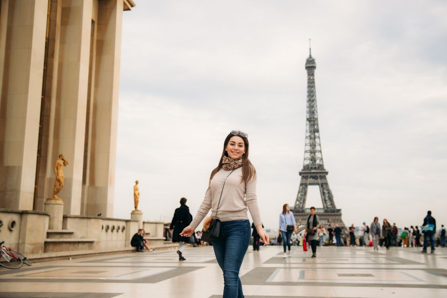 This is an image of a woman posing in front of the Eiffel Tower.