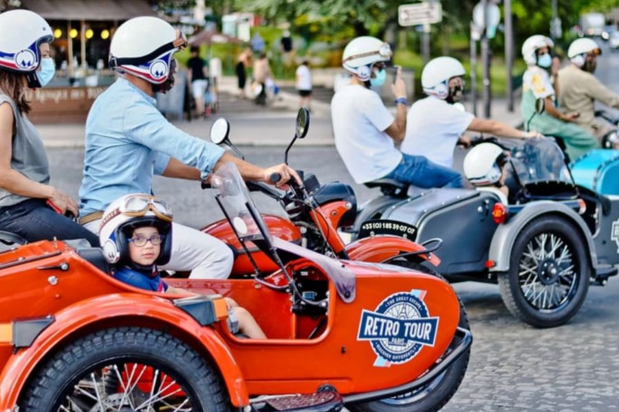 This is an image of a family riding a side car through the Parisian streets.