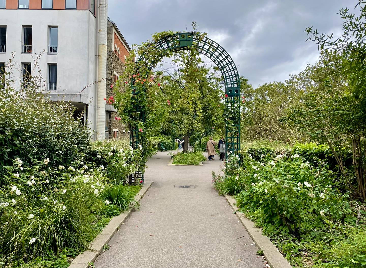 A flower filled archway above a path.