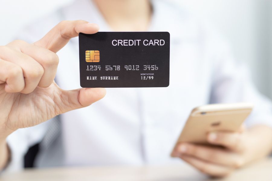 This is an image of a man holding up a credit card.