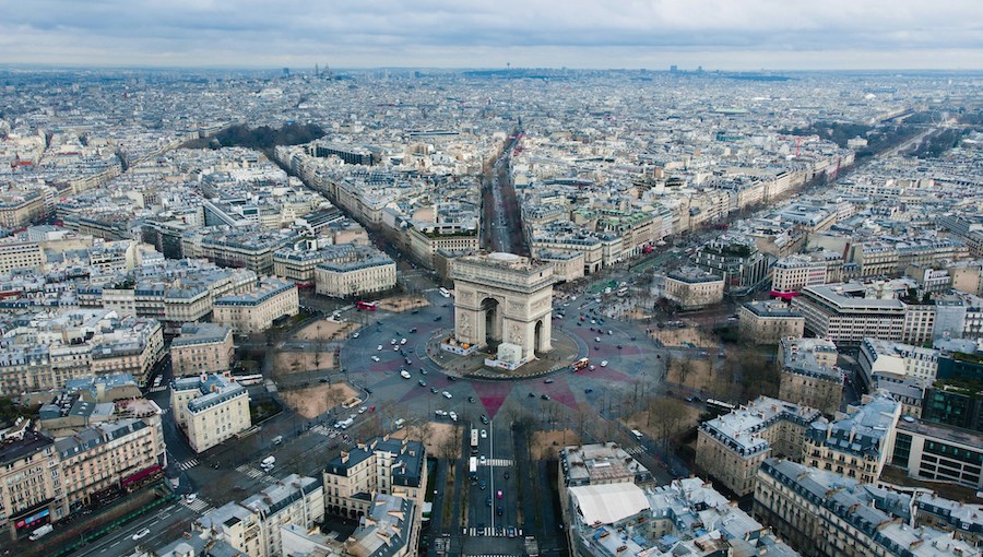 This is an image of a bird's eye view of Paris featuring the Arc De Triomphe in the middle and the streets coming off it.